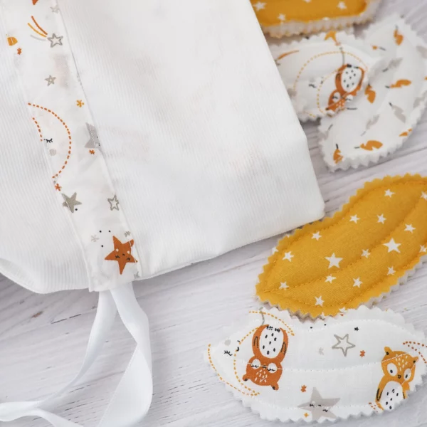 zoom sur le Sac à bisous blanc et moutarde avec un motif de petites Chouettes et de plumes