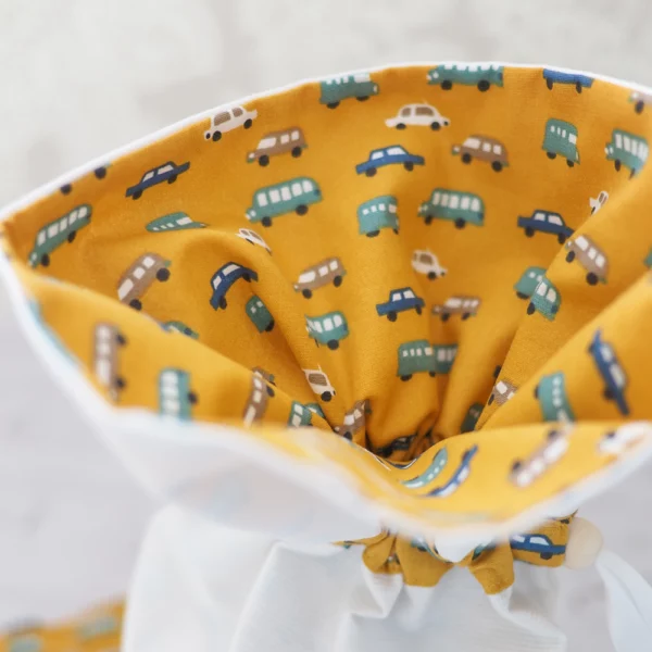 Sac à bisous blanc et moutarde avec un motif de petites voitures