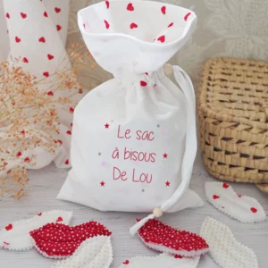 Sac à bisous avec l'intérieur en gaze de coton à l'imprimé coeur rouge entouré des bisous en tissus assorti au sac