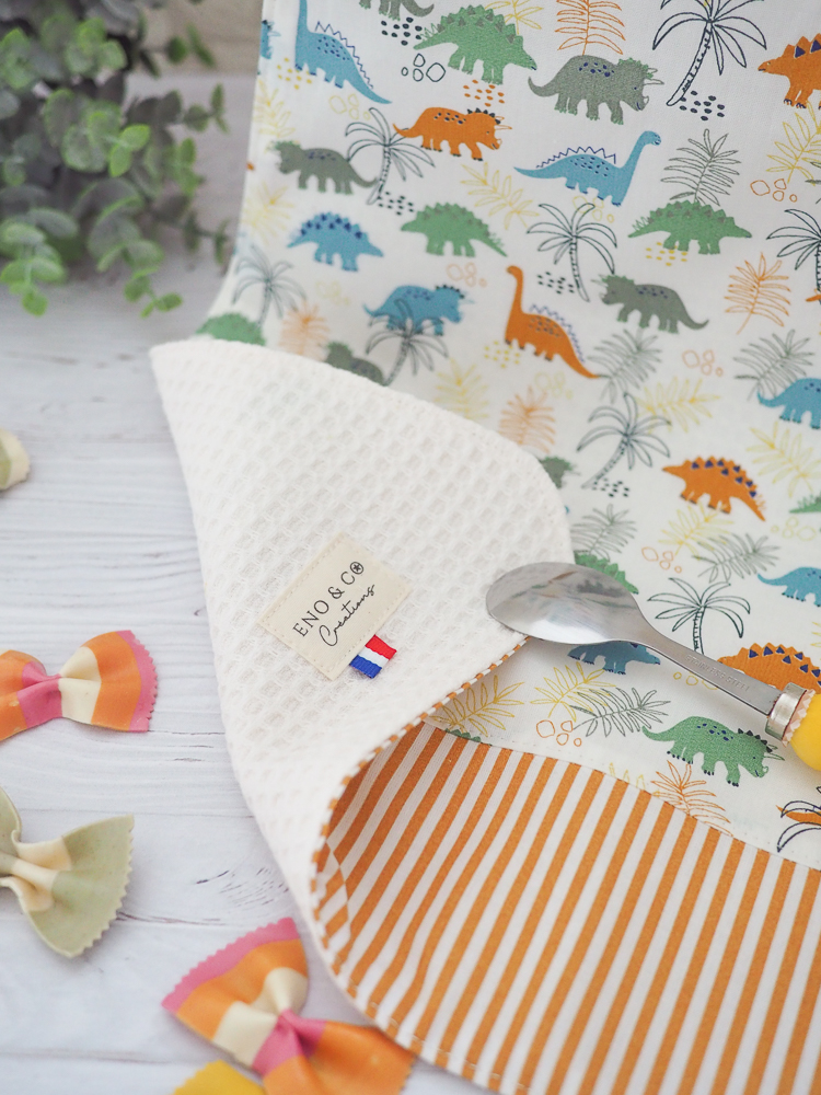 Serviette élastique pour enfant "Les Diplos" avec motif coloré de dinosaures, taille adaptée aux 2-6 ans, en coton doux et nid d’abeille absorbant.